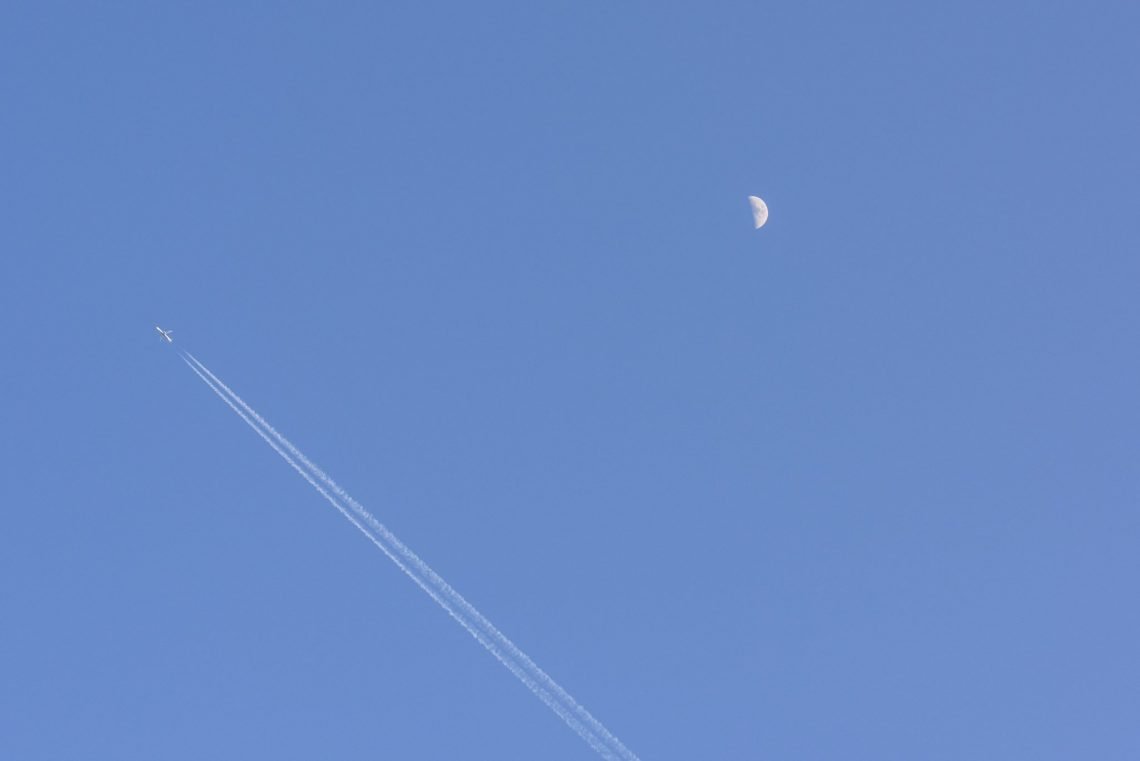 Plane moon and vapor trails